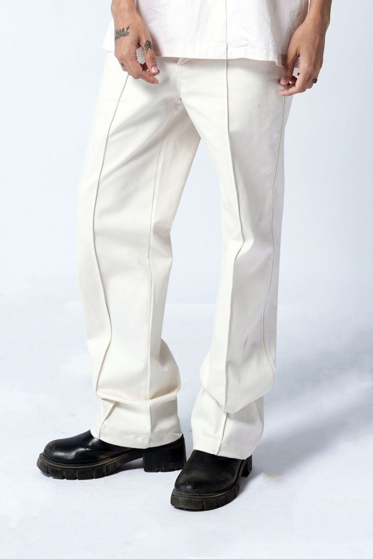 Person wearing off-white old money trousers and black shoes, standing against a white background.